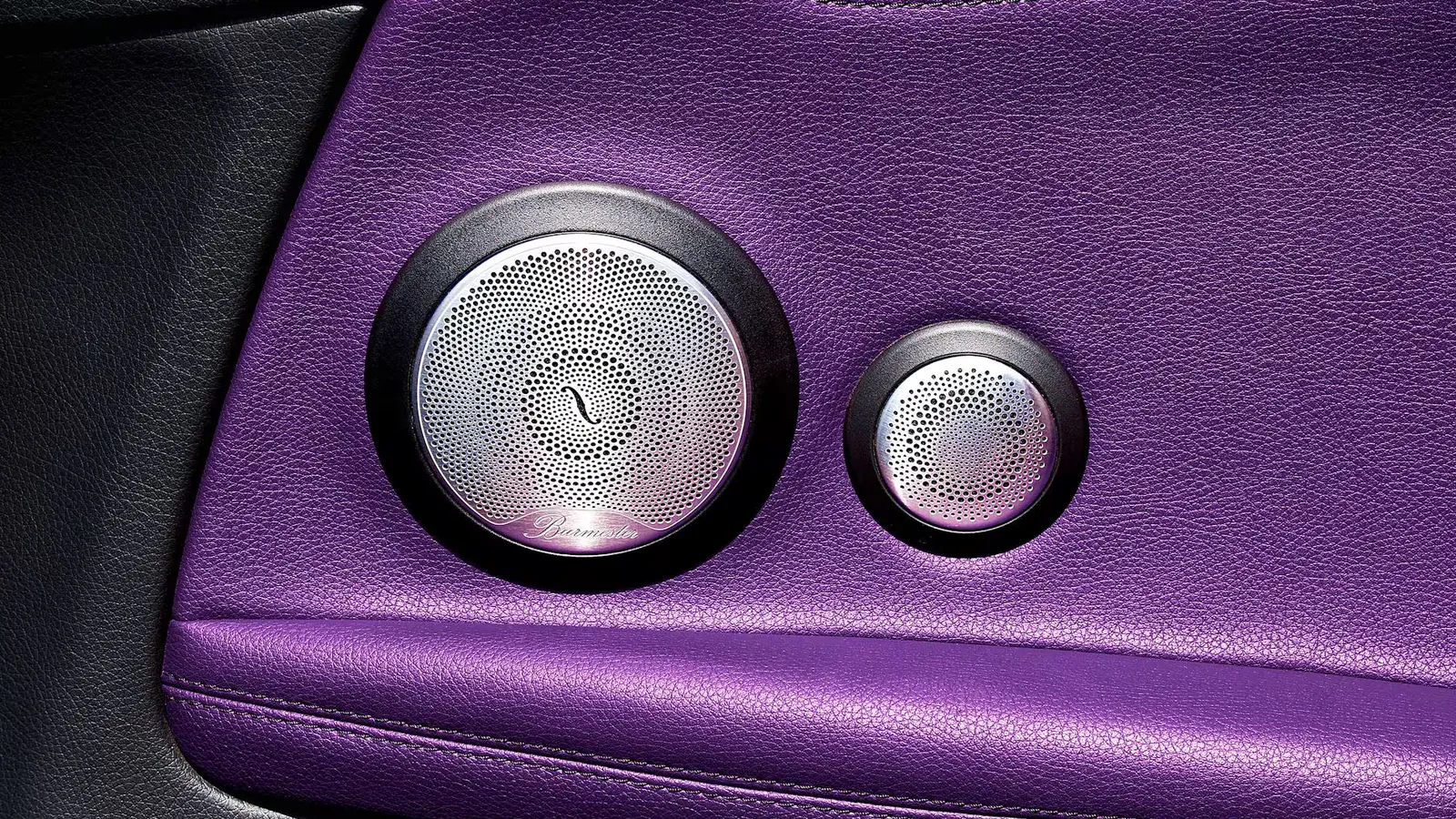 Detailed view of premium car speakers with purple leather accents