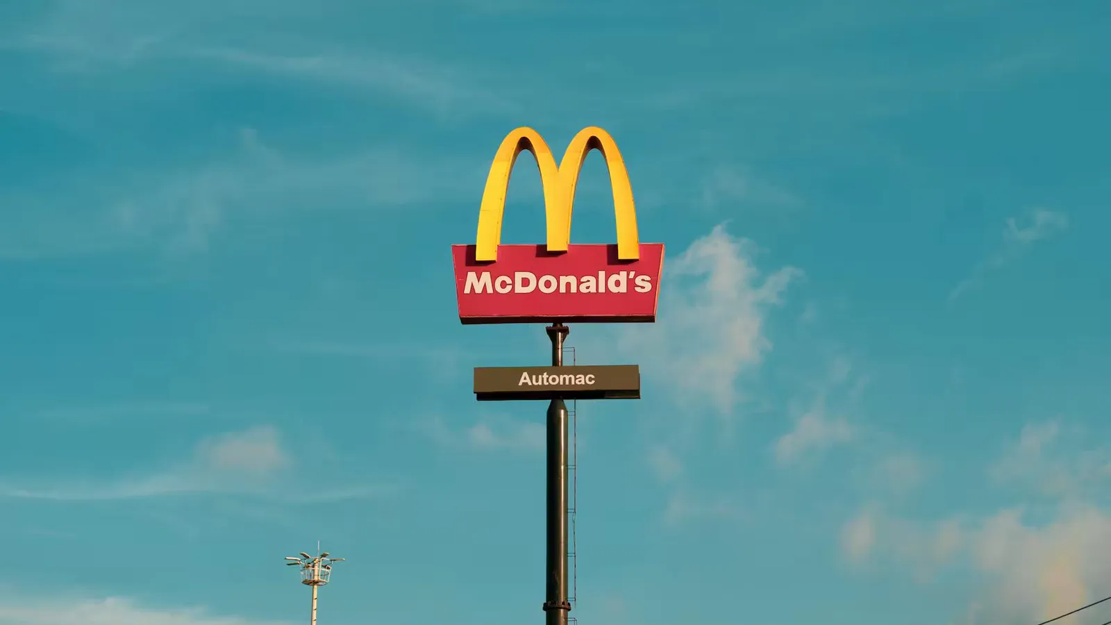 Bright McDonald's sign under clear sky, featuring the 'Automac' label.