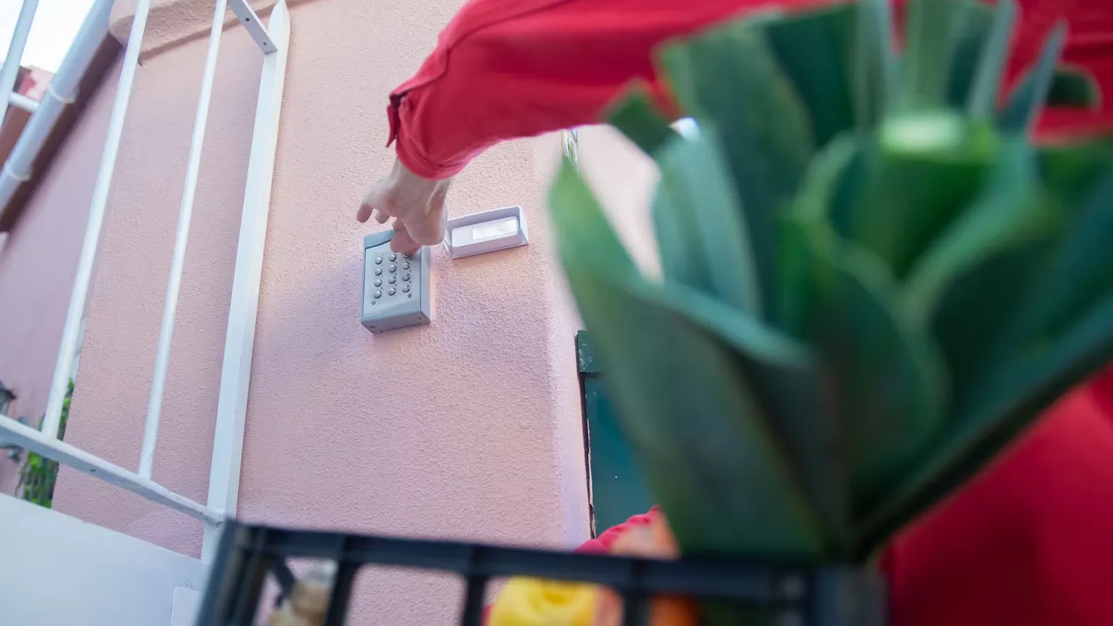 Close-up of a person using a security keypad on a gate, highlighting home access control.